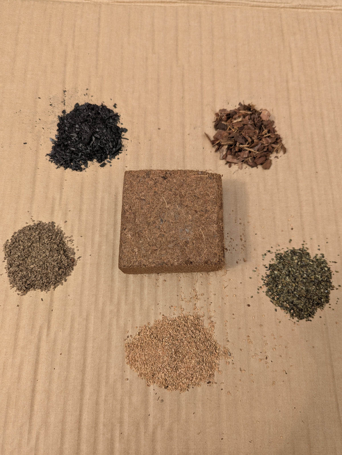 Compost Cube coco brick surrounded by five ingredient samples